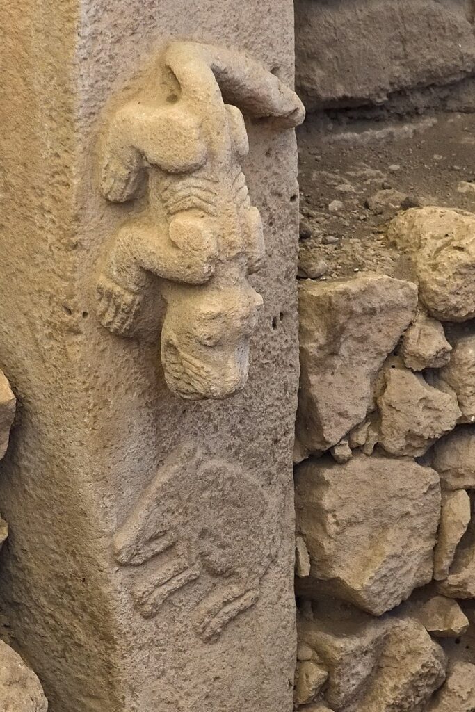 God exist: predator (possibly a felid) in high relief, hunting prey in low relief